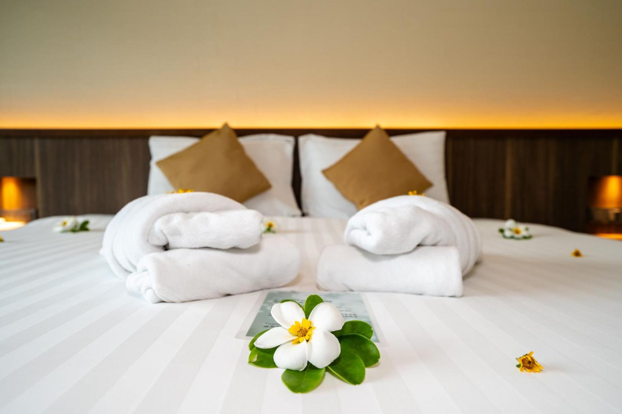 Le Resort And Villas Rawai Dış mekan fotoğraf A bed with towels and flowers
